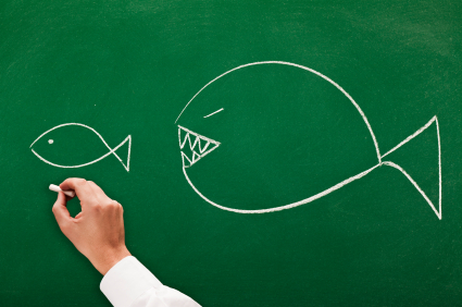 businessman drawing on blackboard concept the big fish eats the small one it's a competitive world